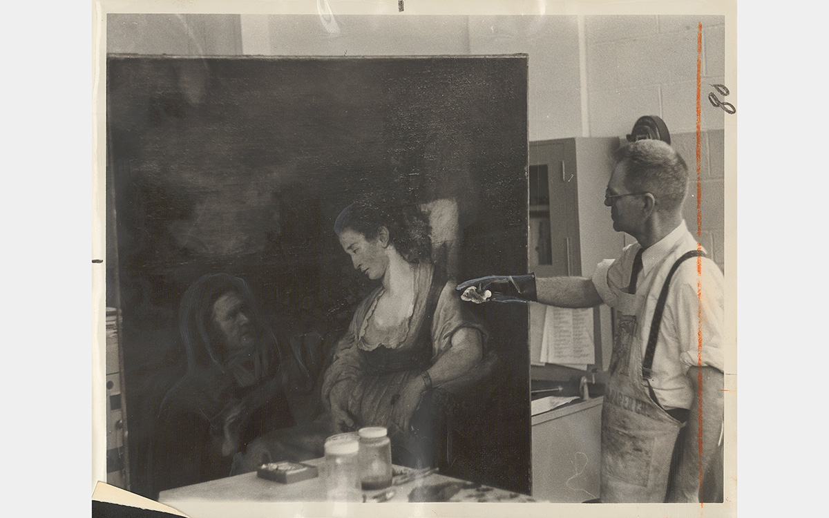 A black and white photo of a man pointing at a large oil painting