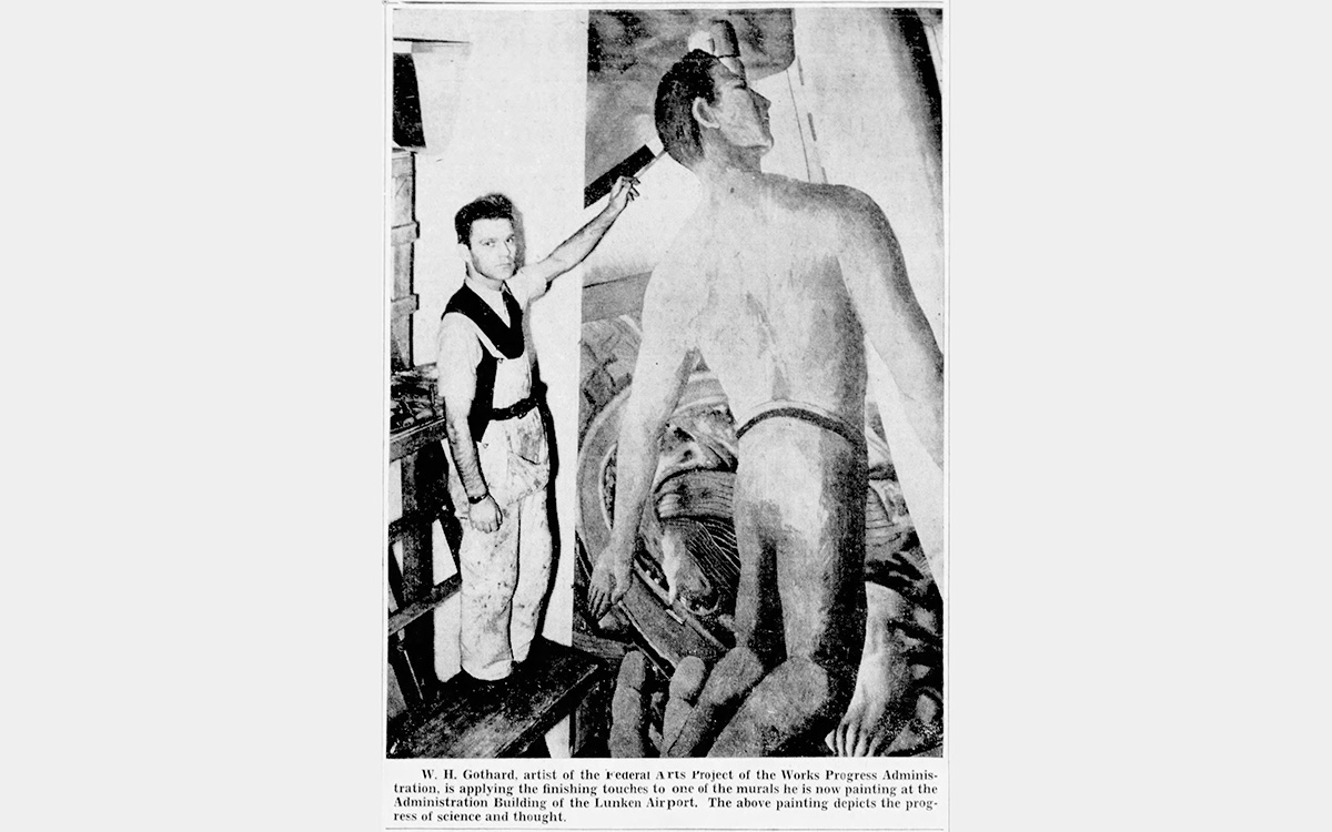 A black and white photo of a white man painting a large mural of a person