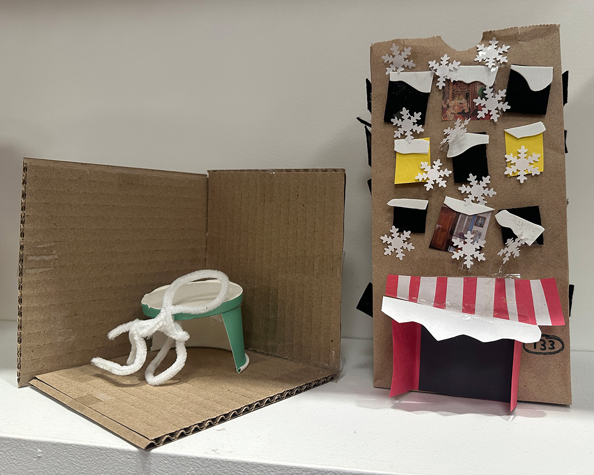 Toy house and patio made of paper and assorted colorful materials.