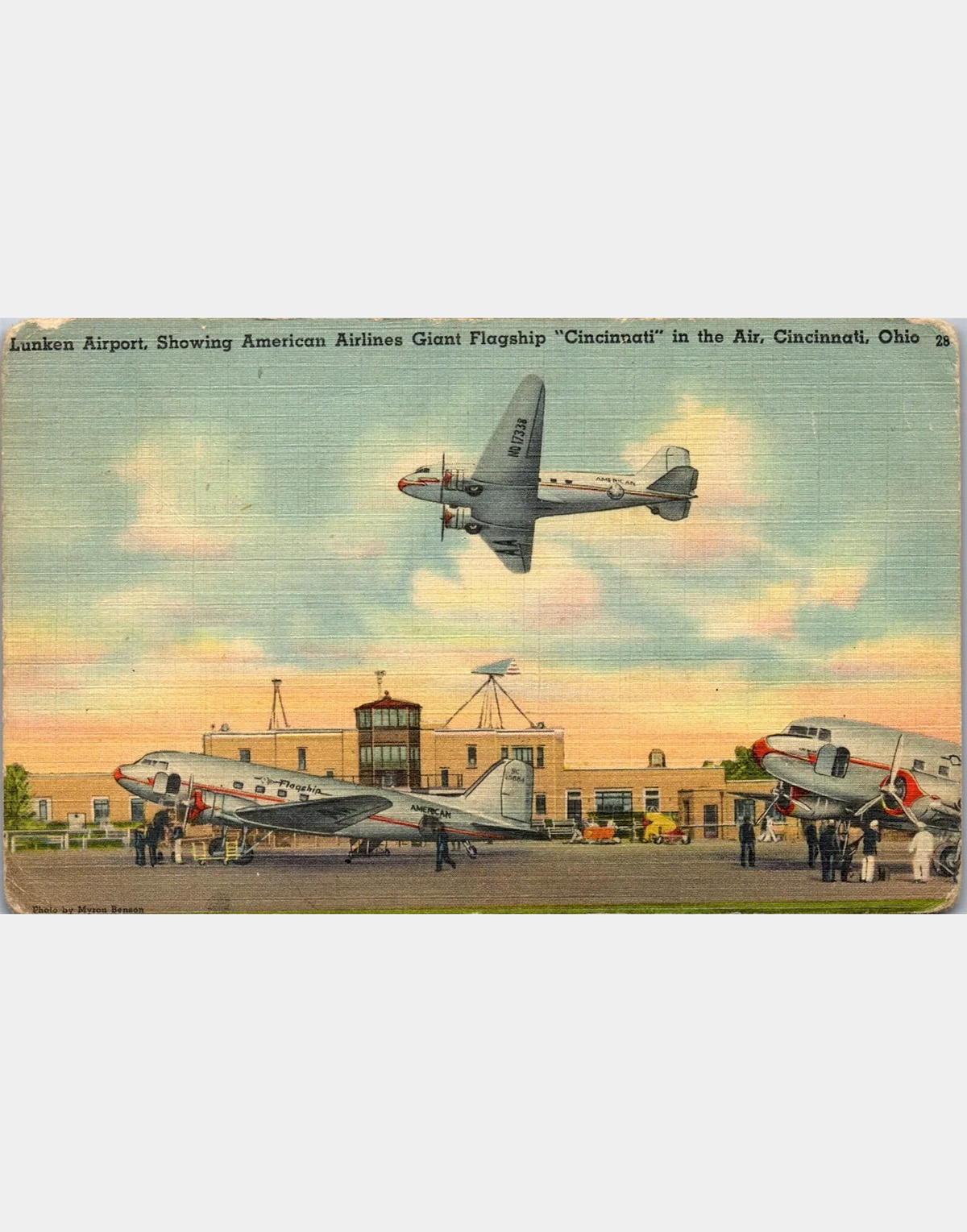 A color postcard of an airplane flying over the airport