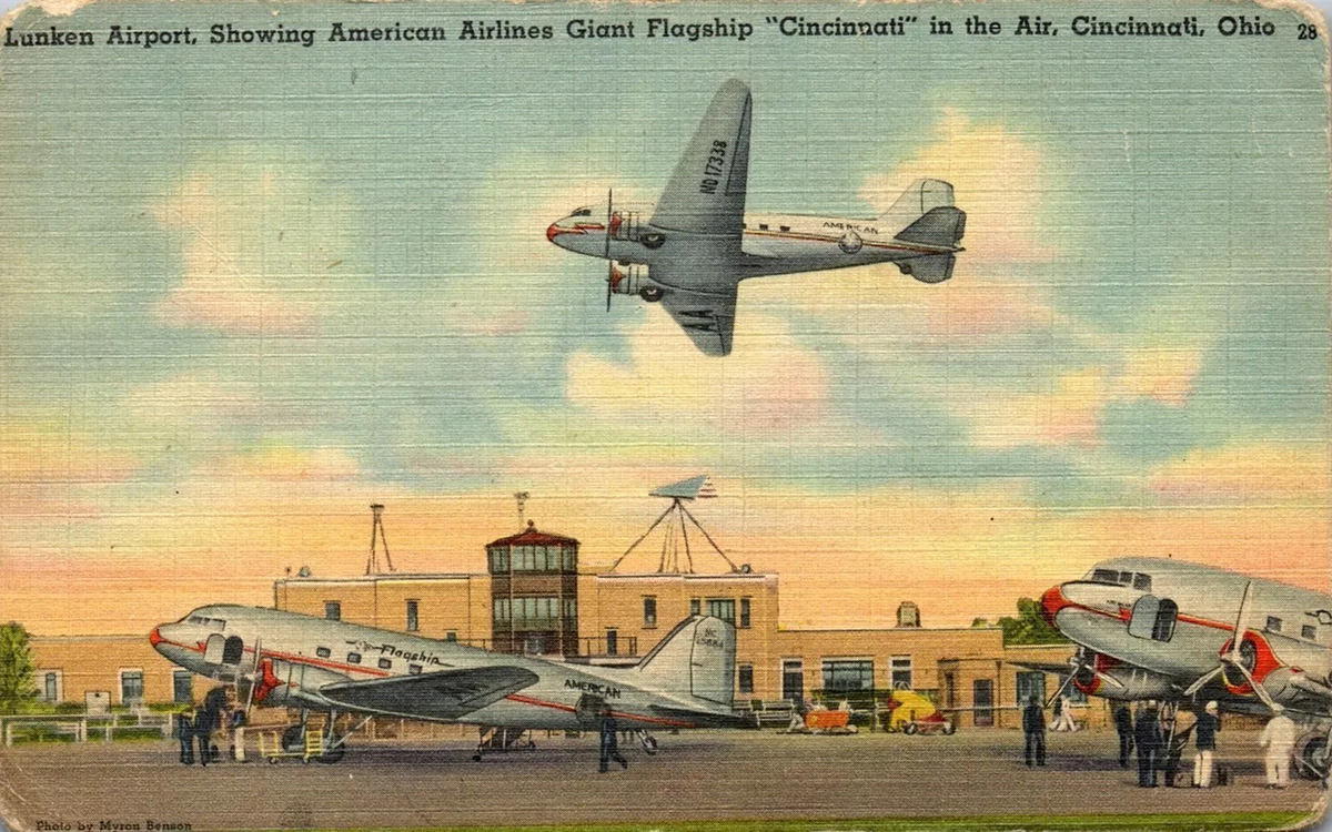 A color postcard of an airplane flying over the airport