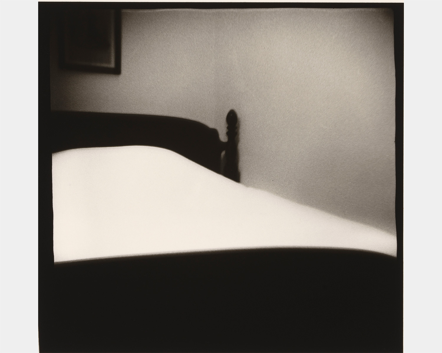A black and white photo of a bed