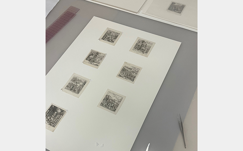 A series of seven tiny prints on a table