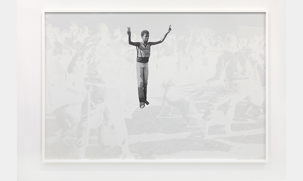 Hank Willis Thomas' Freedom for Soweto, without flash, a screen print of a young African American Boy standing alone holding the peace sign in each hand above his head