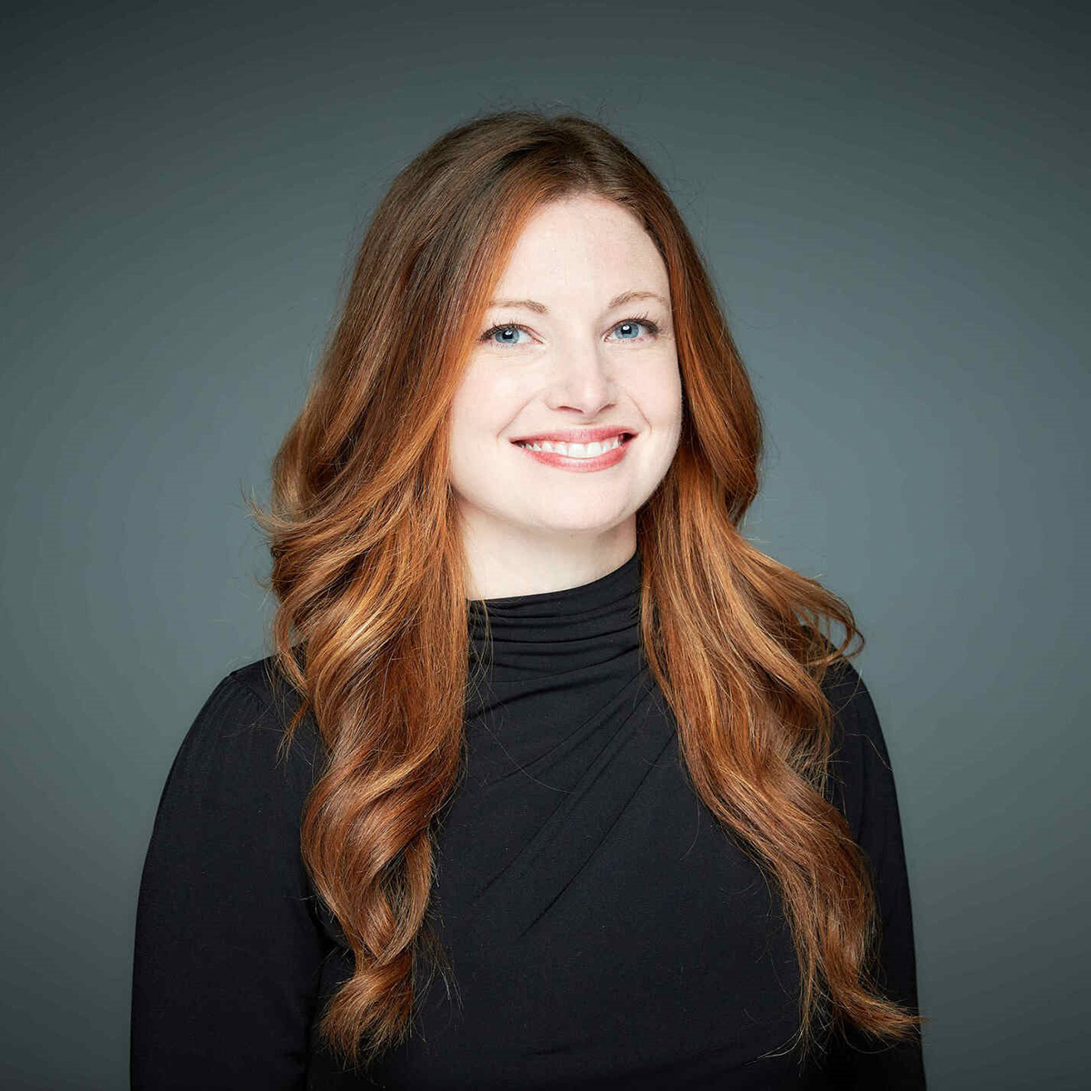 A smiling white woman with red-brown hair