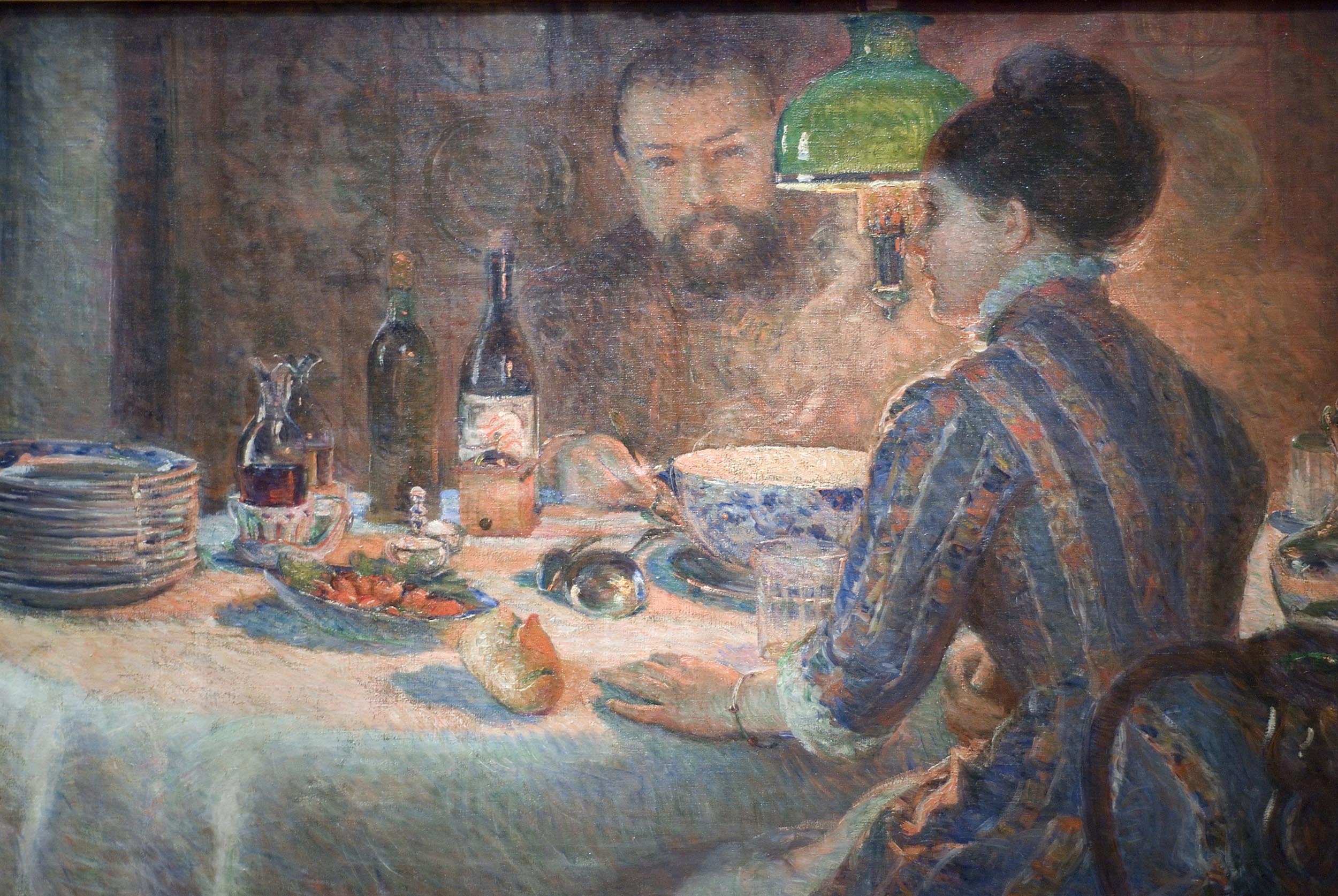 A white couple dine under a green lamp