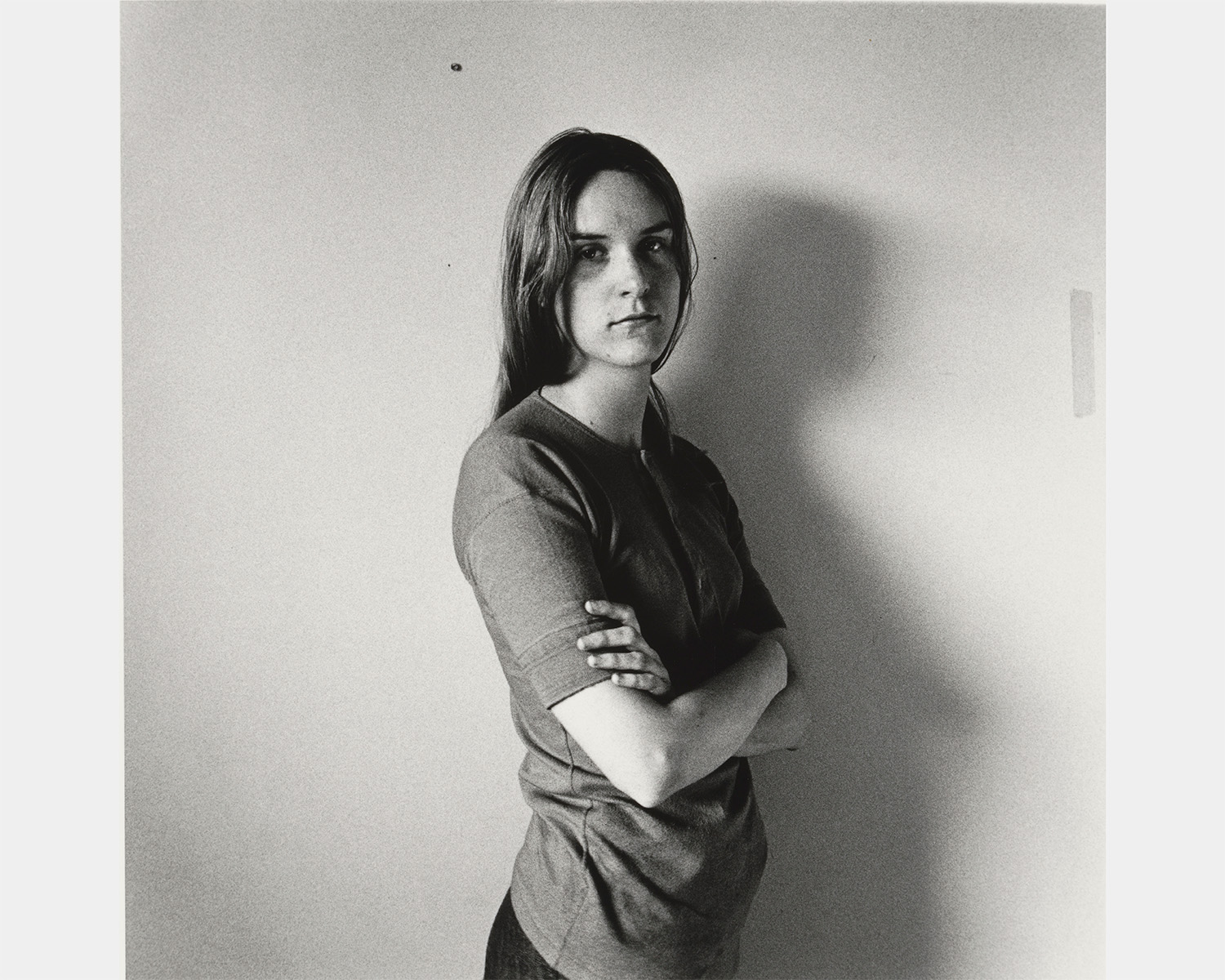 A black and white photo of a white woman with crossed arms