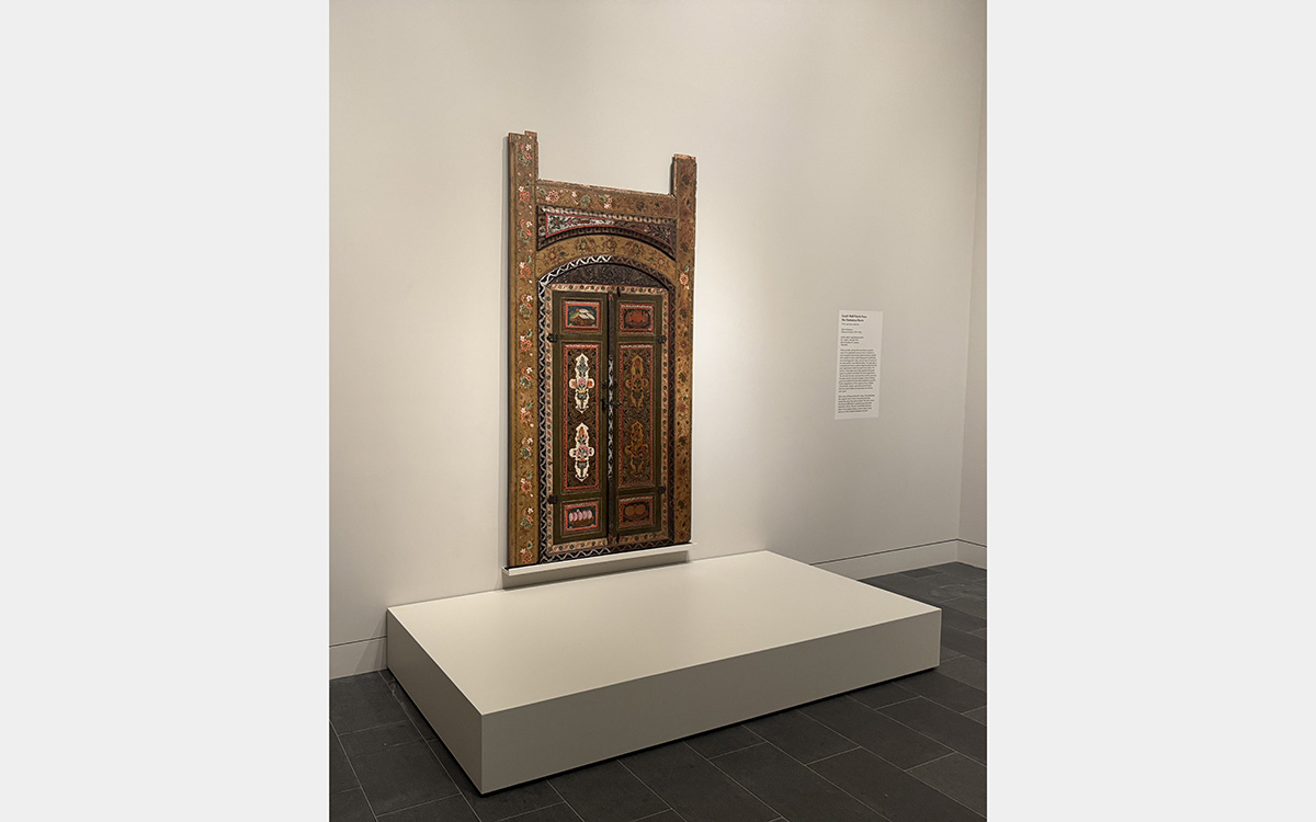 Decorative wooden panels on display in a white-walled museum gallery