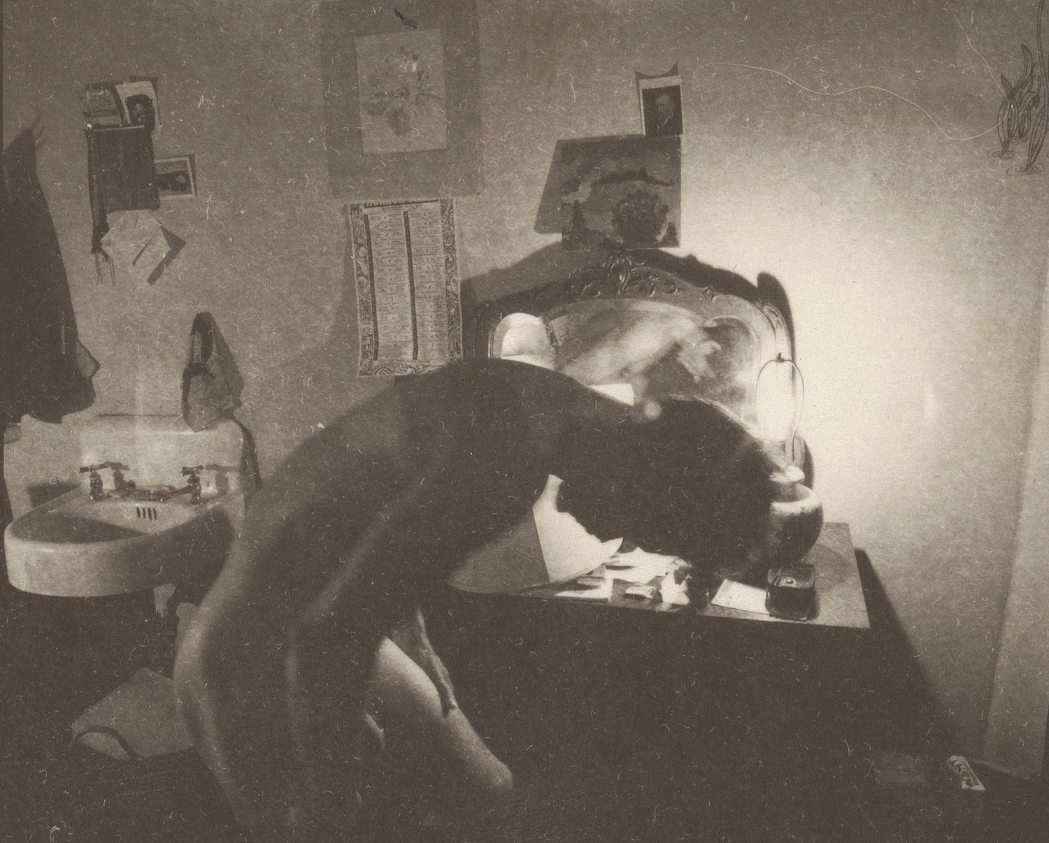 A black and white photo of a white man in an apartment