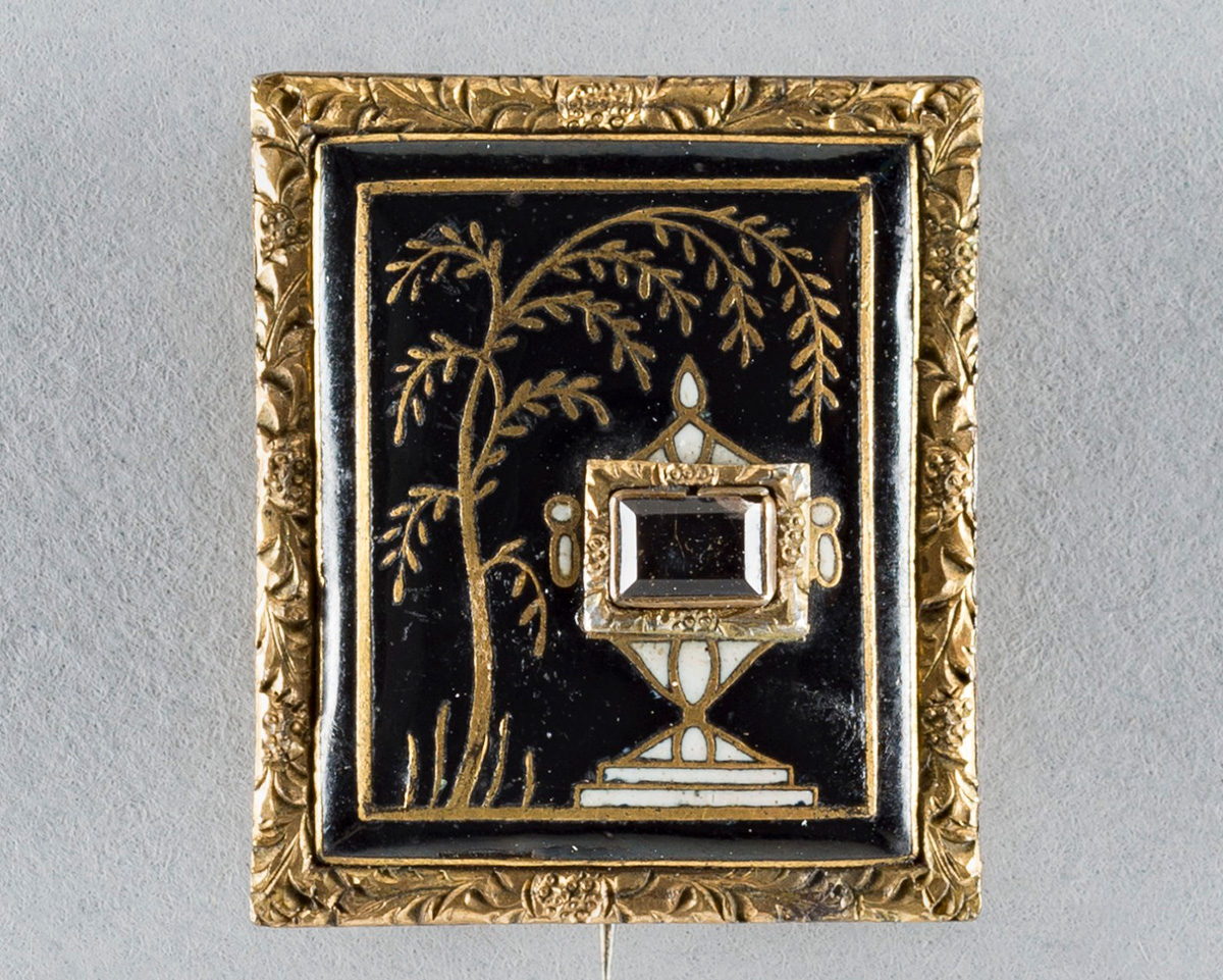 Gold-framed brooch decorated with images of a funerary urn and a weeping willow tree.