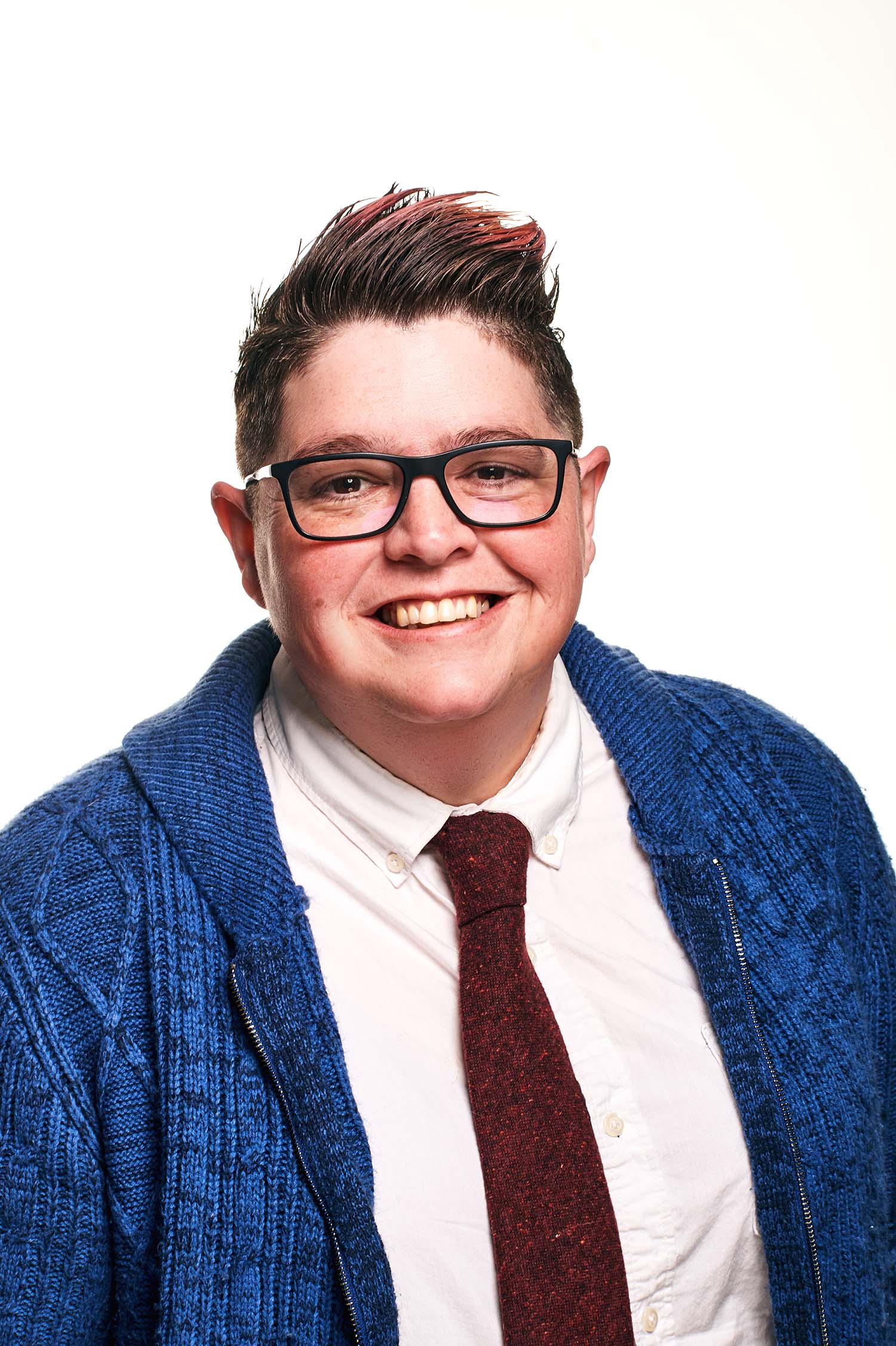 A smiling white person in a shirt and tie