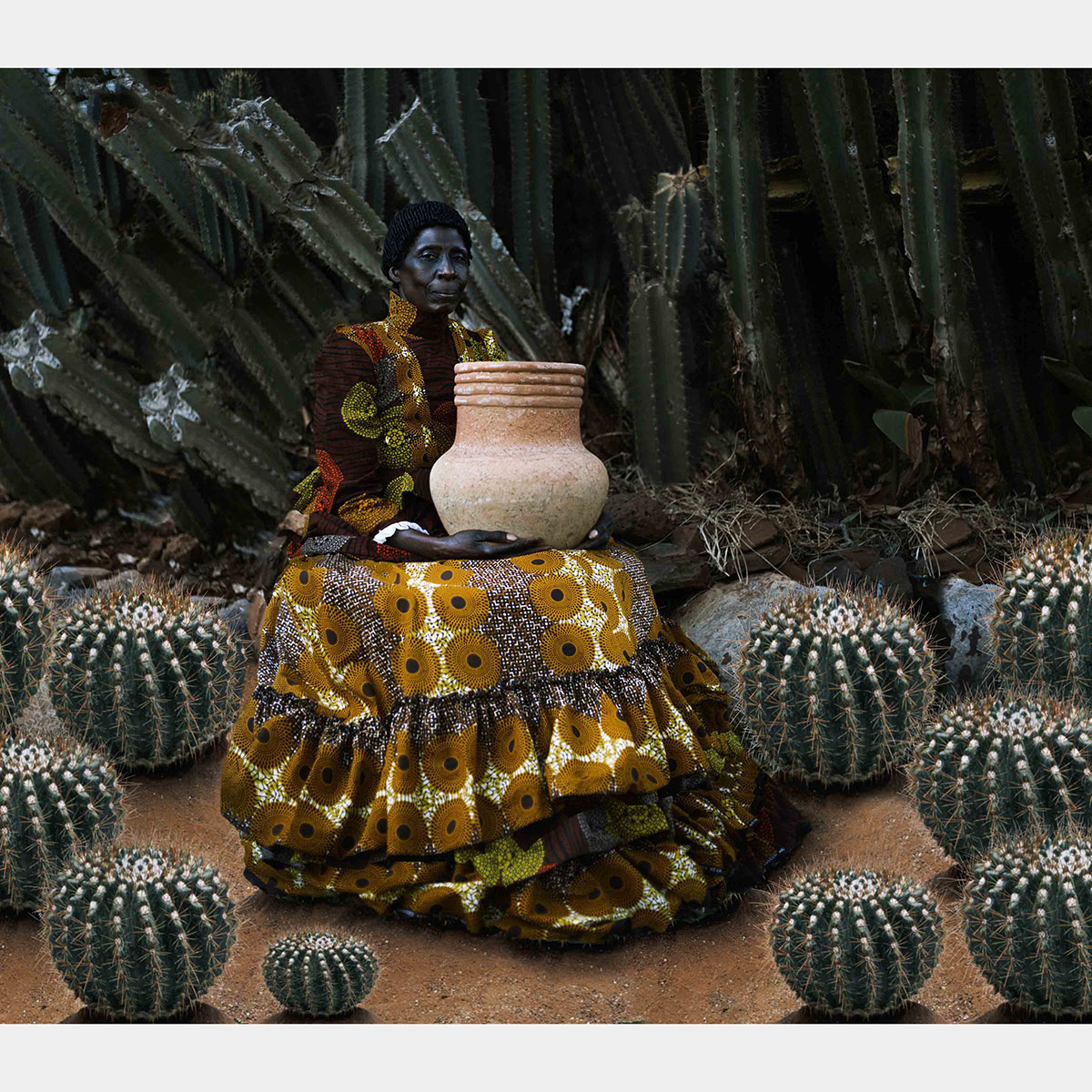 A Black woman wearing a large gown holds a large clay pot