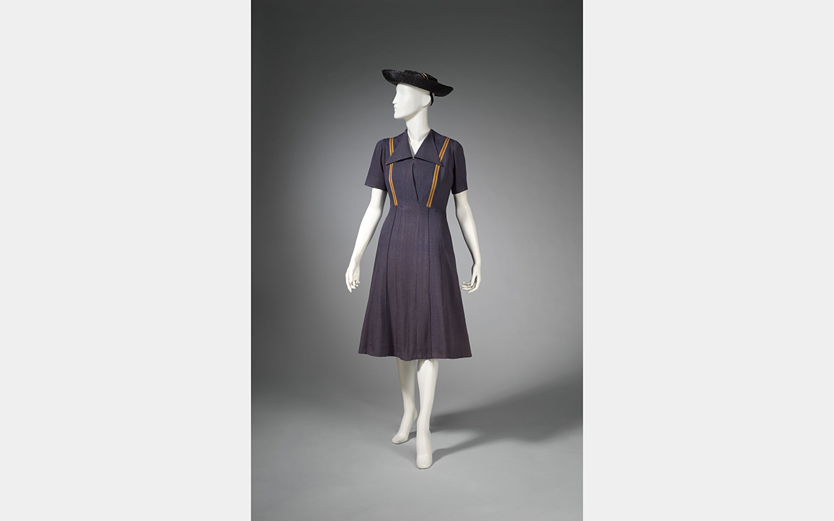 White mannequin wearing a bluish-gray colored dress and hat