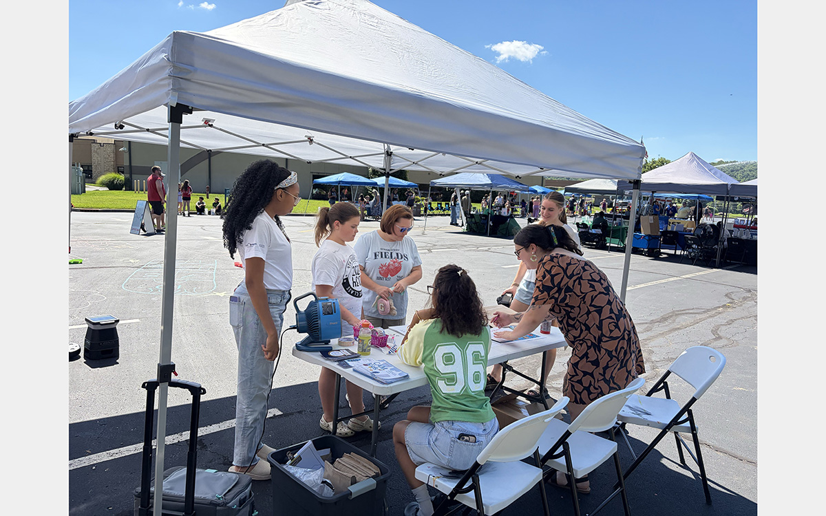 People under a tent in a parking lot