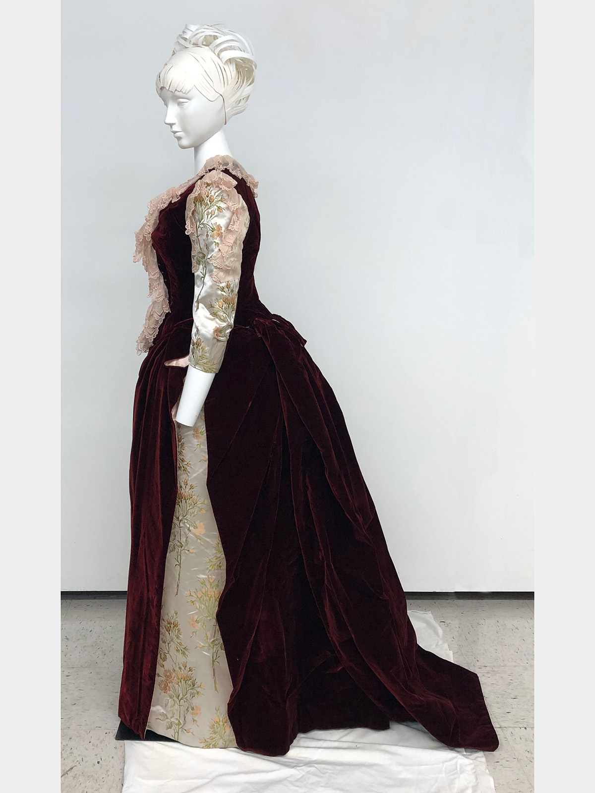 Side view of a red velvet dress on a mannequin