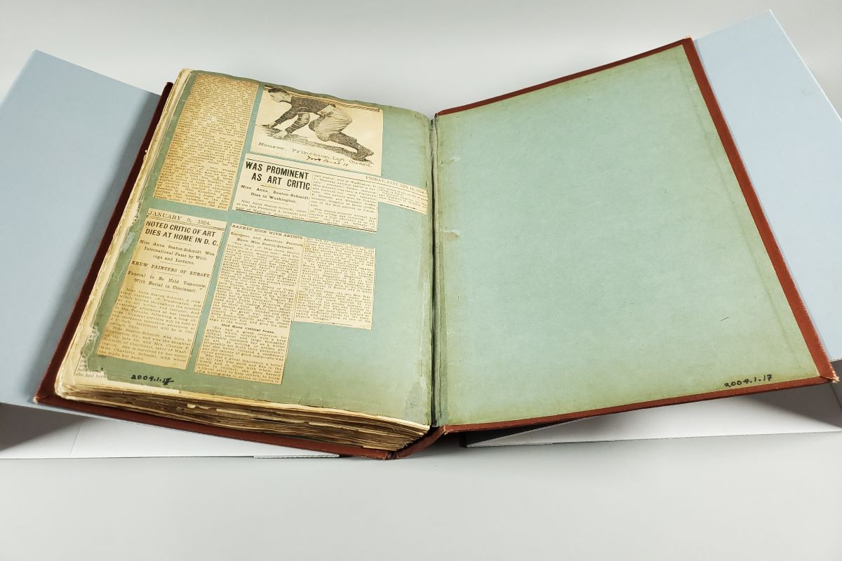 Open scrapbook with newspaper clippings and inside back cover.