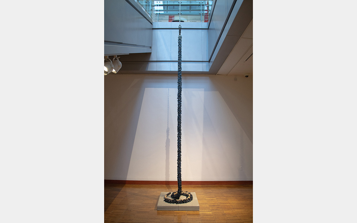 Stack of small ceramic pieces that resembles a rope descending from the ceiling  