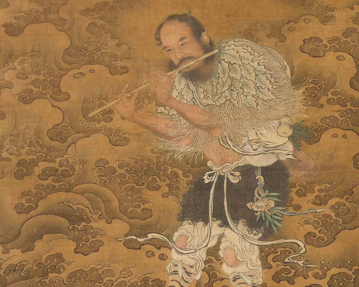 An Asian man plays a flute in a rough sea