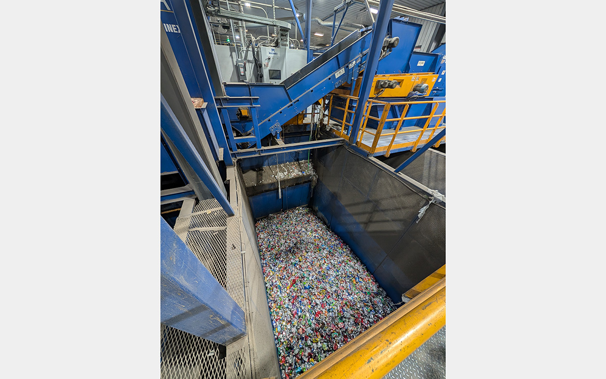 Above view looking down into a large bin filled with hundreds of aluminum cans