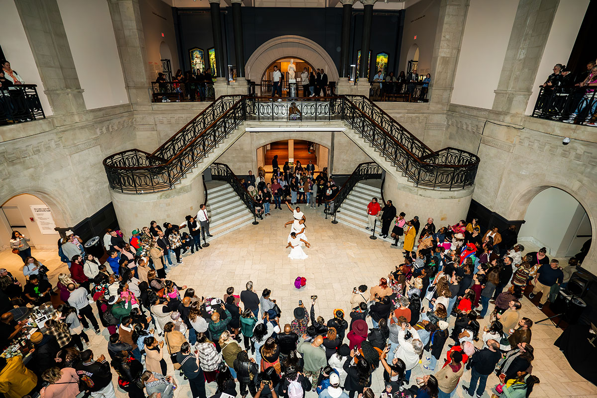 People gather around a group of Black dancers in the Great Hall