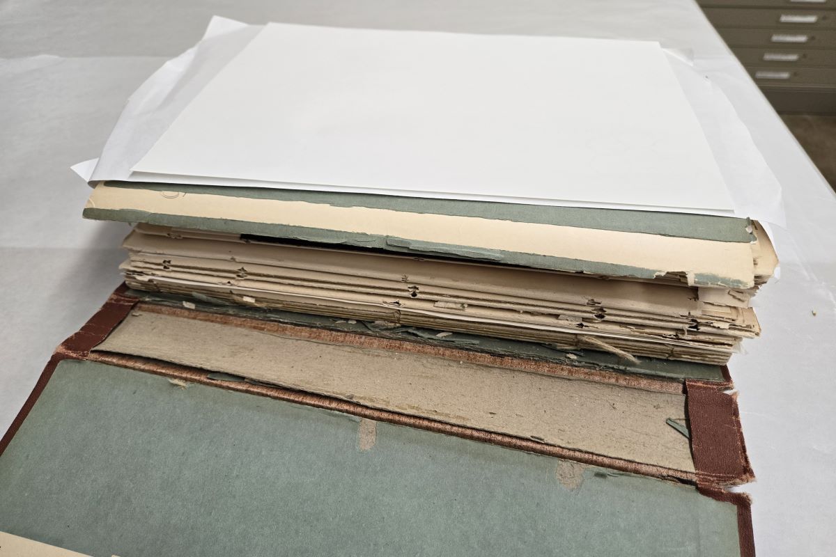 Open scrapbook showing binding dislodged from cover.