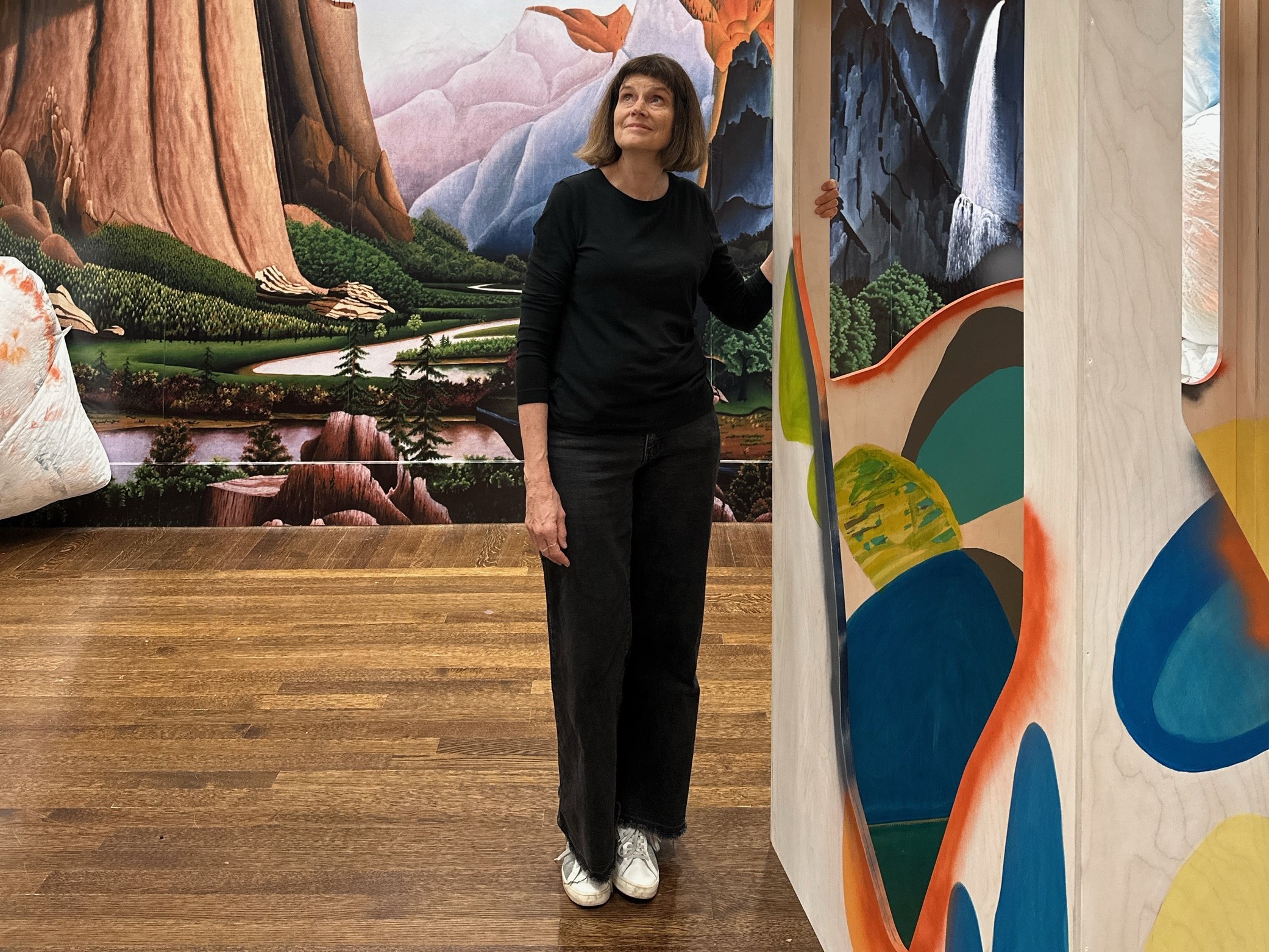 Woman stands in an art installation, looking up.