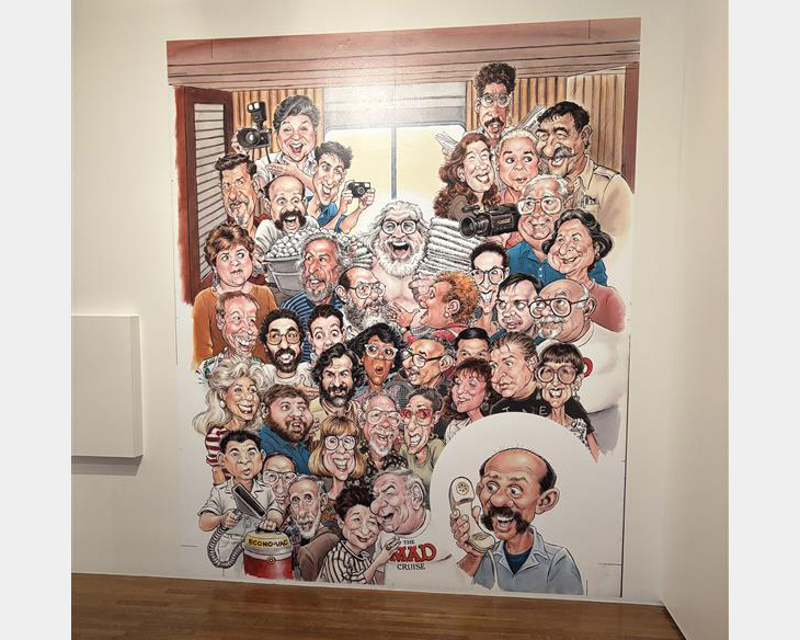 Large graphic on white wall featuring dozens of people drawn in cartoon style.
