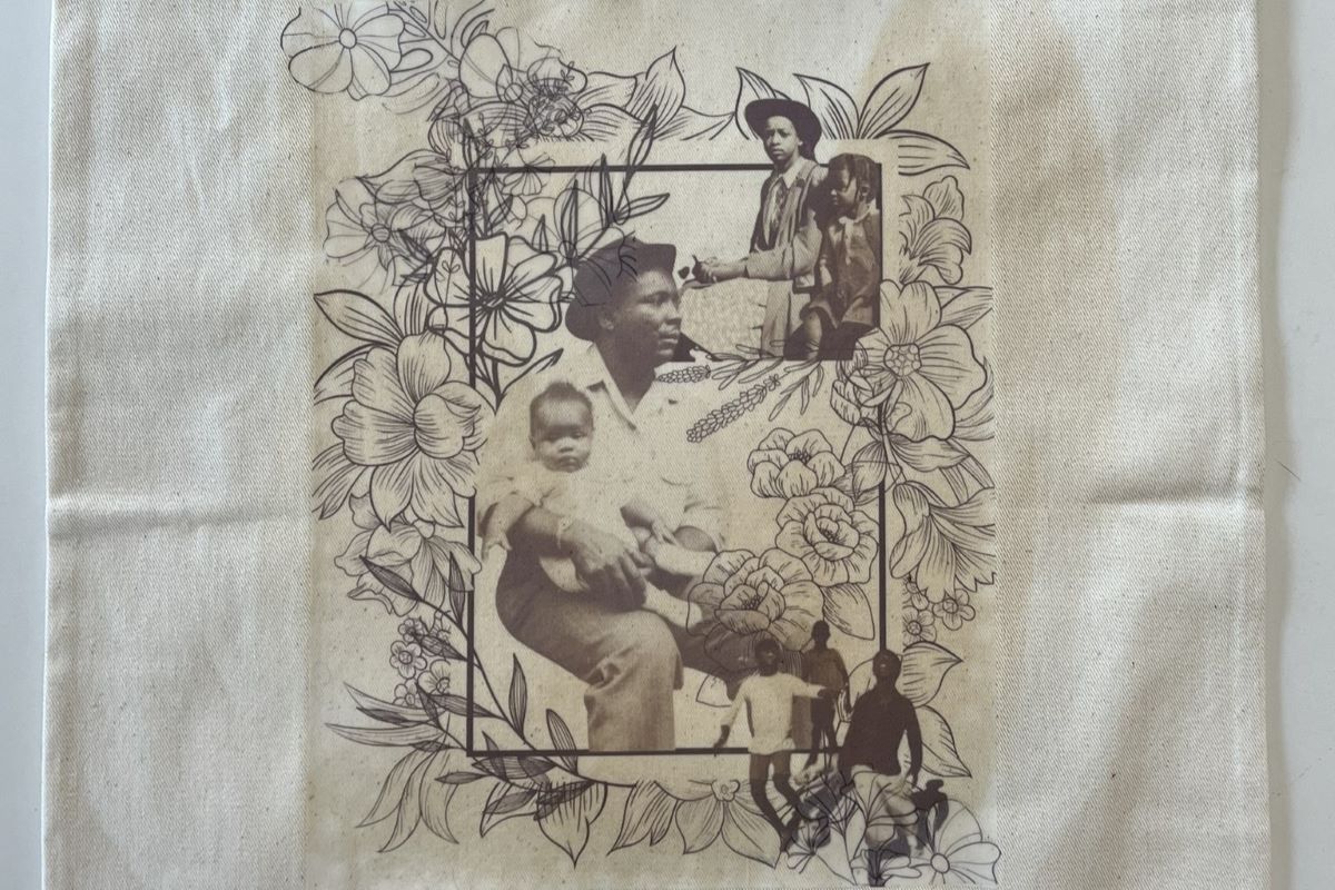Cloth carrying bag featuring printed photographic images of people and illustrations of flowers.