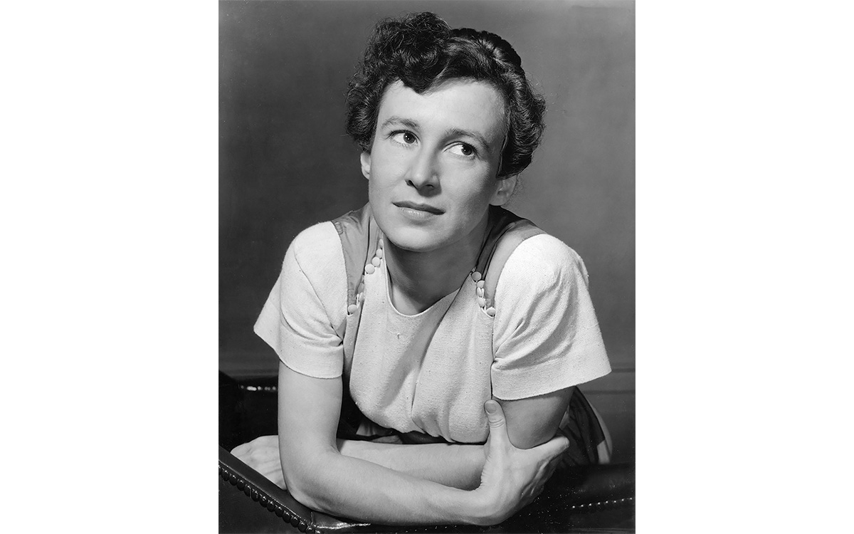 Black and white photographic portrait of a woman with short-cropped hair in a white shirt