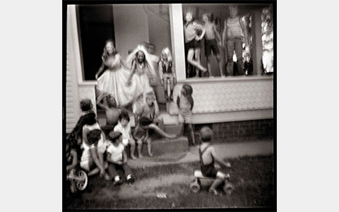 Nancy Rexroth's Group Portrait, black and white photograph of a group of children sitting on a staircase and railing to a porch