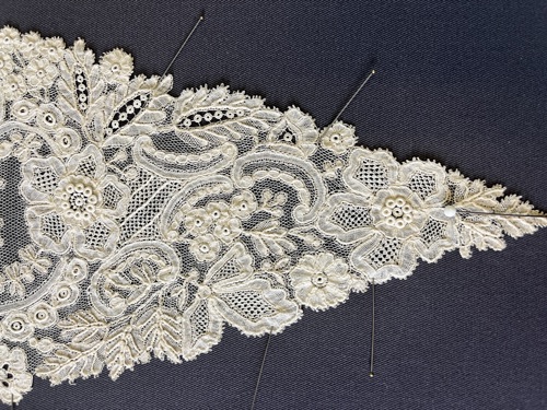 A piece of lace pinned to a board