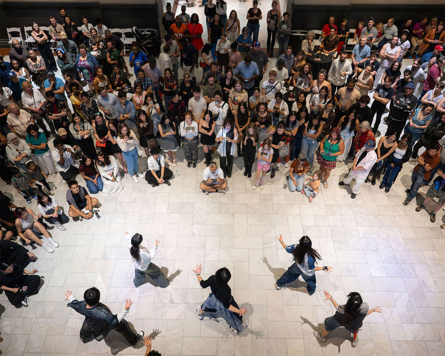 A massive crowd surrounds a handful of dancers in the Great Hall